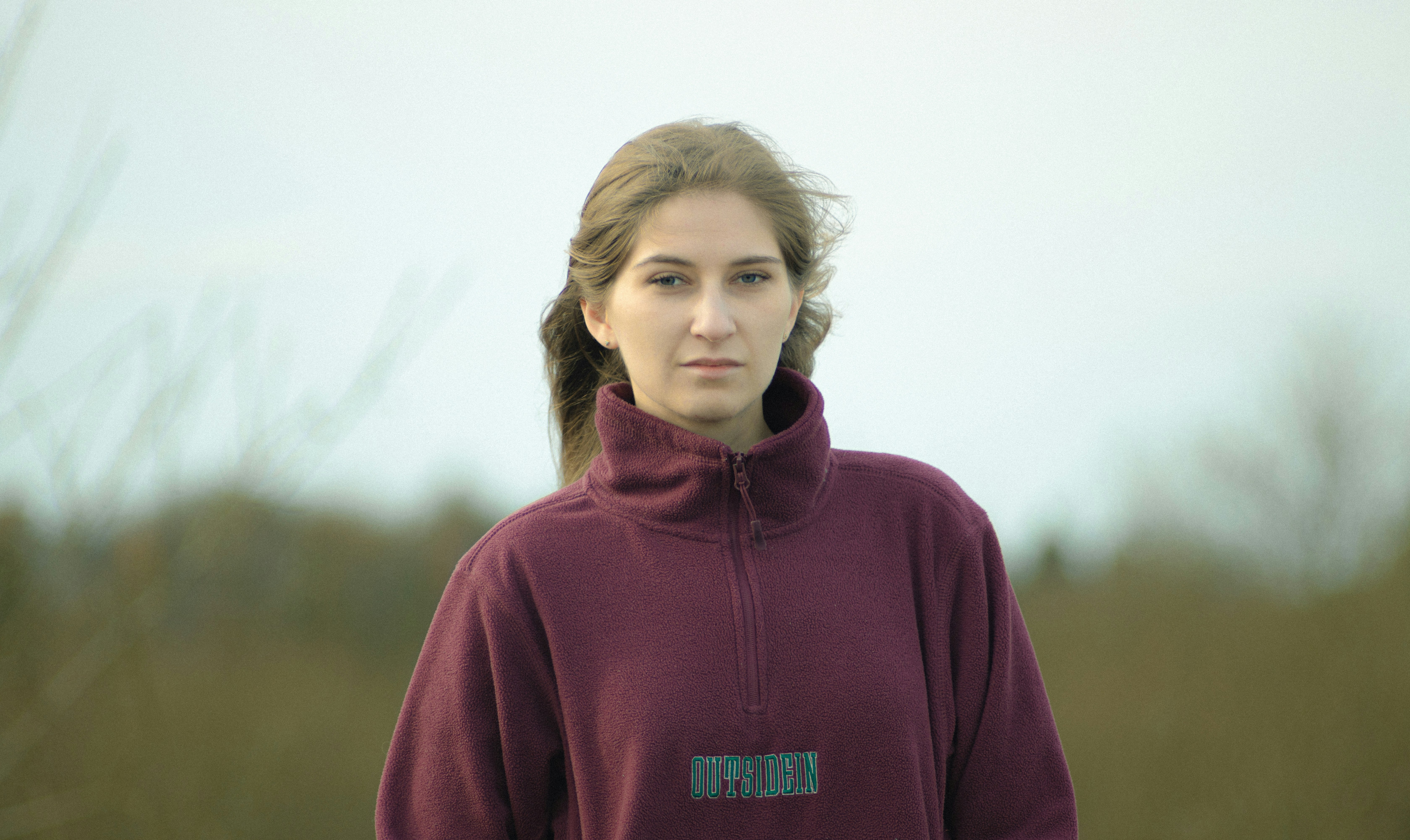 girl in maroon hoodie standing